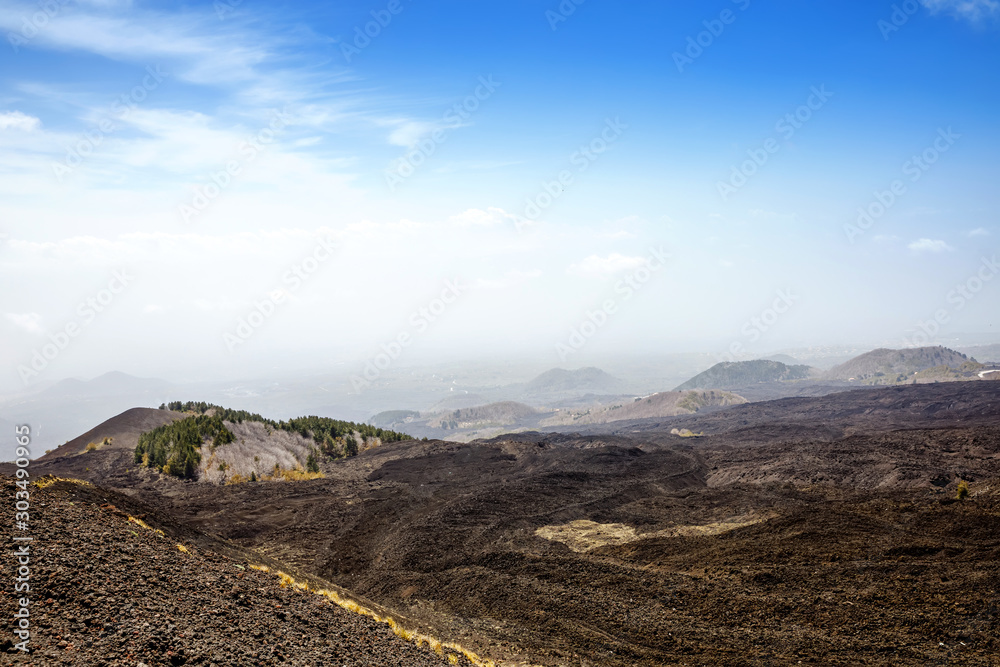 Panoramic wide view of the active volcano Etna on island Sicily, Italy extinct craters on the slope, traces of volcanic activity. Barren landscape of lava stones
