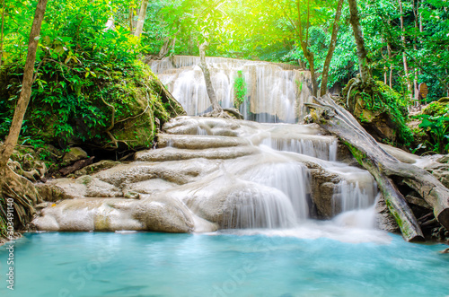 Deep forest waterfall at Erawan waterfall, beautiful waterfall with sunlight rays in deep forest, Erawan National Park in Kanchanaburi, Thailand