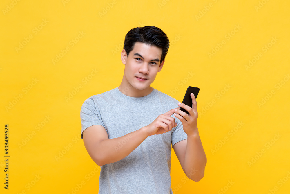 Handsome young Asian man using smartphone Handsome young Asian man using smartphone