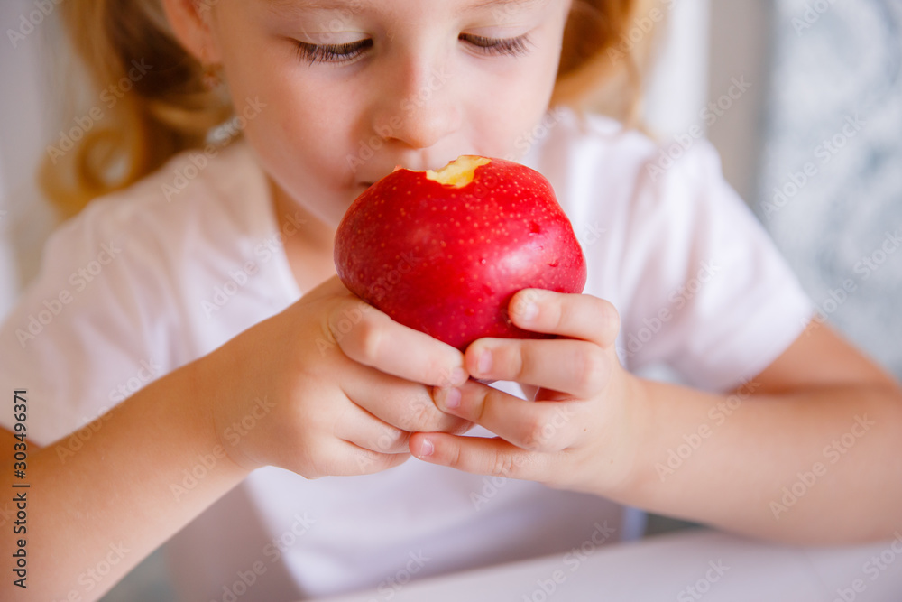 blonde baby girl eating vegetables in the kitchen blonde baby girl eating vegetables in the kitchen