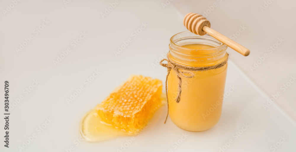 Φωτογραφία Honey dipper and jar of creamed amber organic honey bee harvest next to fresh honeycomb healthy food banner panorama