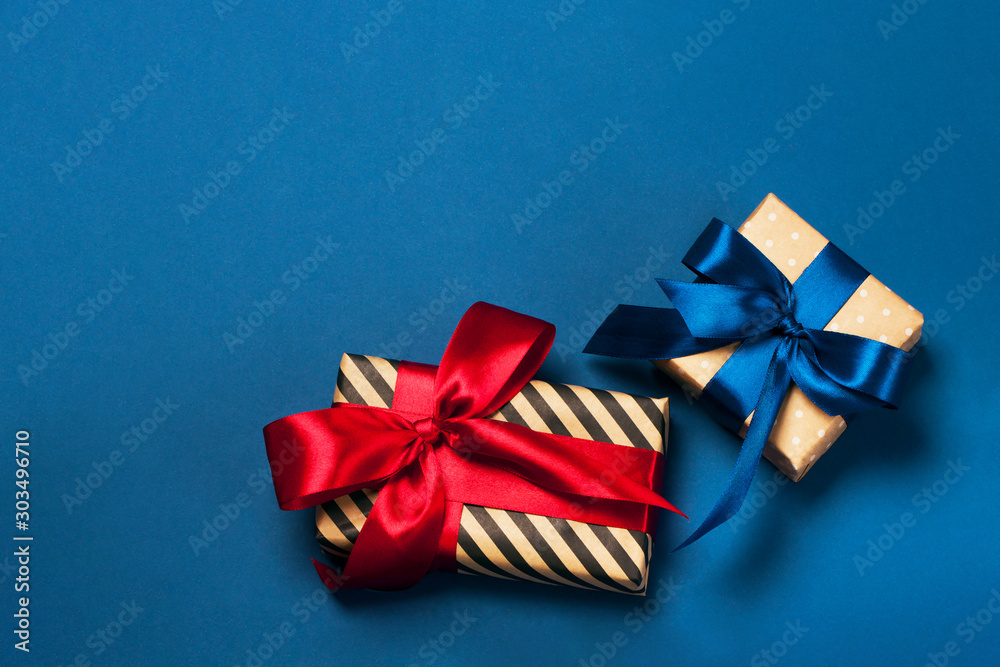 Luxuriously wrapped gifts with lush ribbon. Trendy red and blue colors. Merry Christmas, St. Valentine's Day, Happy Birthday and other holidays concept.