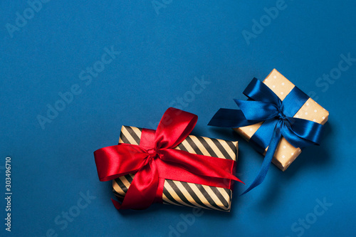 Fototapeta Naklejka Na Ścianę i Meble -  Luxuriously wrapped gifts with lush ribbon. Trendy red and blue colors. Merry Christmas, St. Valentine's Day, Happy Birthday and other holidays concept.
