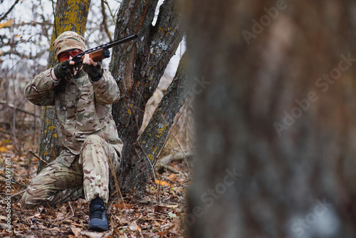 Hunter in uniform with a hunting rifle. Hunting Concept