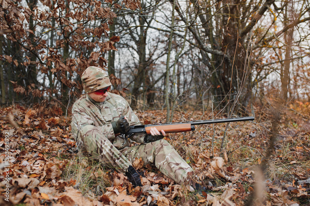 Fototapeta premium Hunter in uniform with a hunting rifle. Hunting Concept