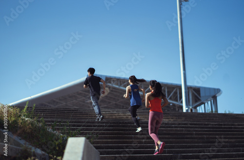 Asian friends group jogging up the stairs