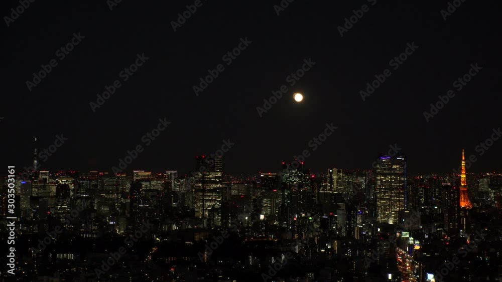 TOKYO, JAPAN - NOVEMBER 2019 : Aerial high angle view of cityscape of TOKYO at night. Scenery of central downtown area and business district. Full moon in the sky. TOKYO, JAPAN - NOVEMBER 2019 : Aerial high angle view of cityscape of TOKYO at night. Scenery of central downtown area and business district. Full moon in the sky.