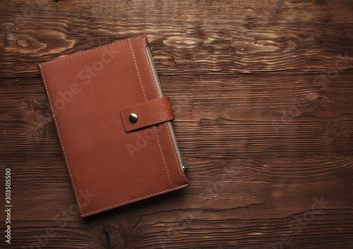 Leather diary on a  wooden brown background photo