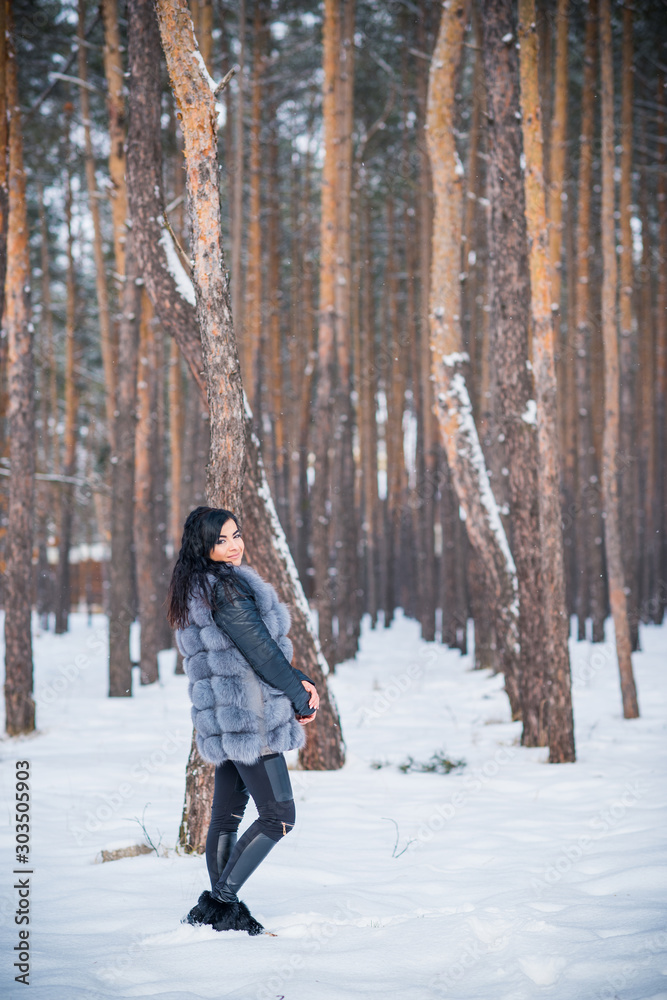 Winter holidays concept. Arabic woman in stylish look at snowy day outside