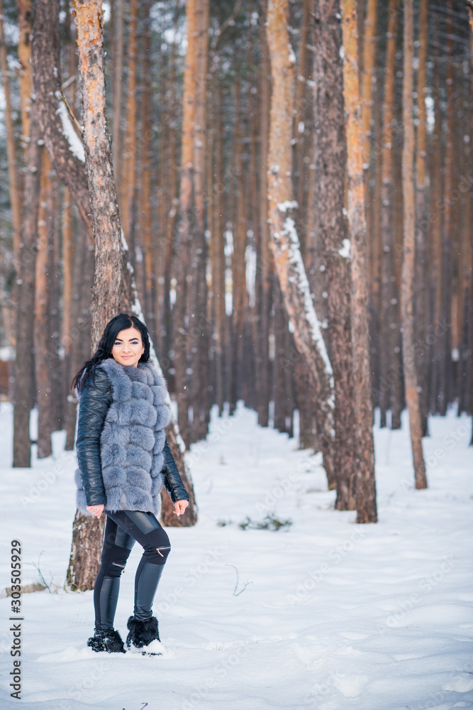 Winter holidays concept. Arabic woman in stylish look at snowy day outside