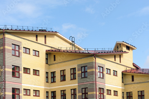 The house with plastic windows and a roof of corrugated sheet. Roofing of metal profile wavy shape on the house with plastic windows.