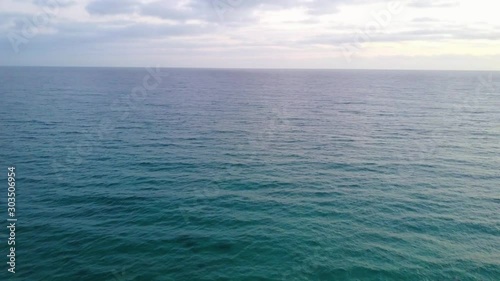 Wallpaper Mural Aerial Drone Panning Above Turquoise Blue Calm Ocean Water At Sunset On A Sunny Day With White Clouds In The Sky Torontodigital.ca
