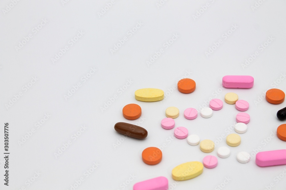 pills on white background are forming heart symbol