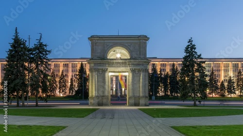 Zoom out: Chisinau, Moldova - the Triumphal arch at sunset. Timelapse of the Triumphal arch and Moldova Government House. Establishing shot of the city of Chisinau and Moldova. Day to Night timelapse photo