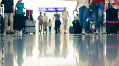 Scene of traveller with luggage reflection on floor in airport during busy hour