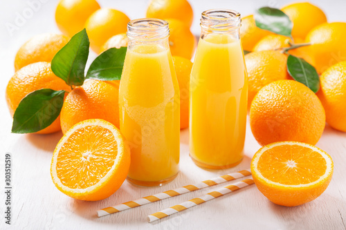 bottles of fresh orange juice with fresh fruits