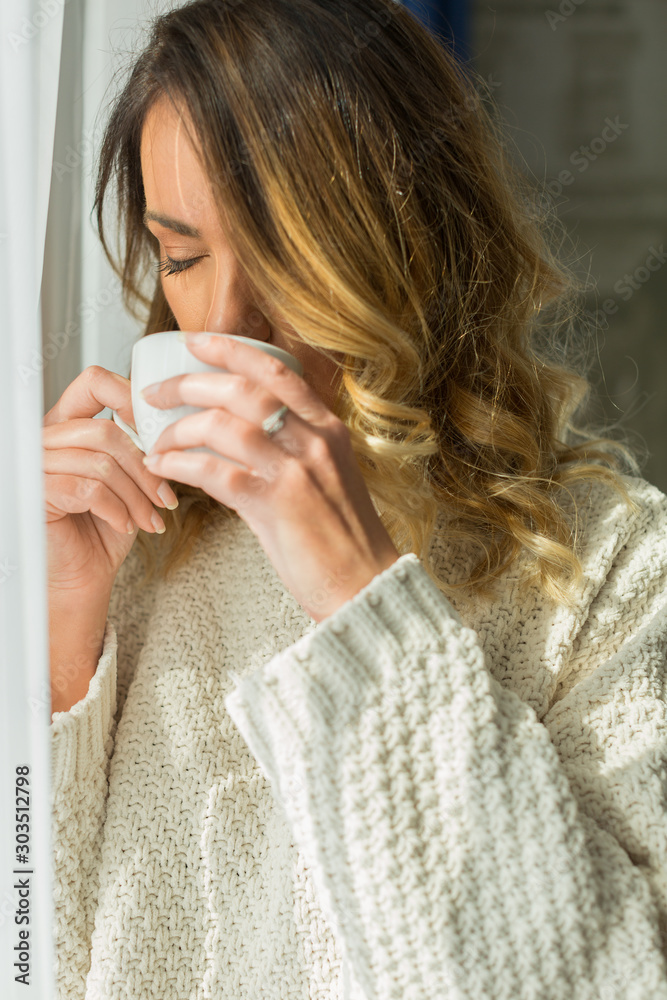 Attractive young woman drinking coffee in a hotel room Attractive young woman drinking coffee in a hotel room
