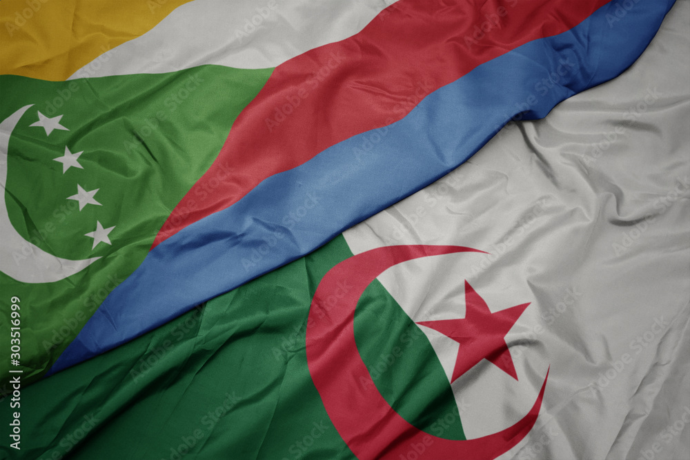 waving colorful flag of algeria and national flag of comoros.
