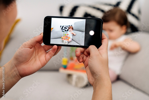 Mother taking a photo of her baby daughter.