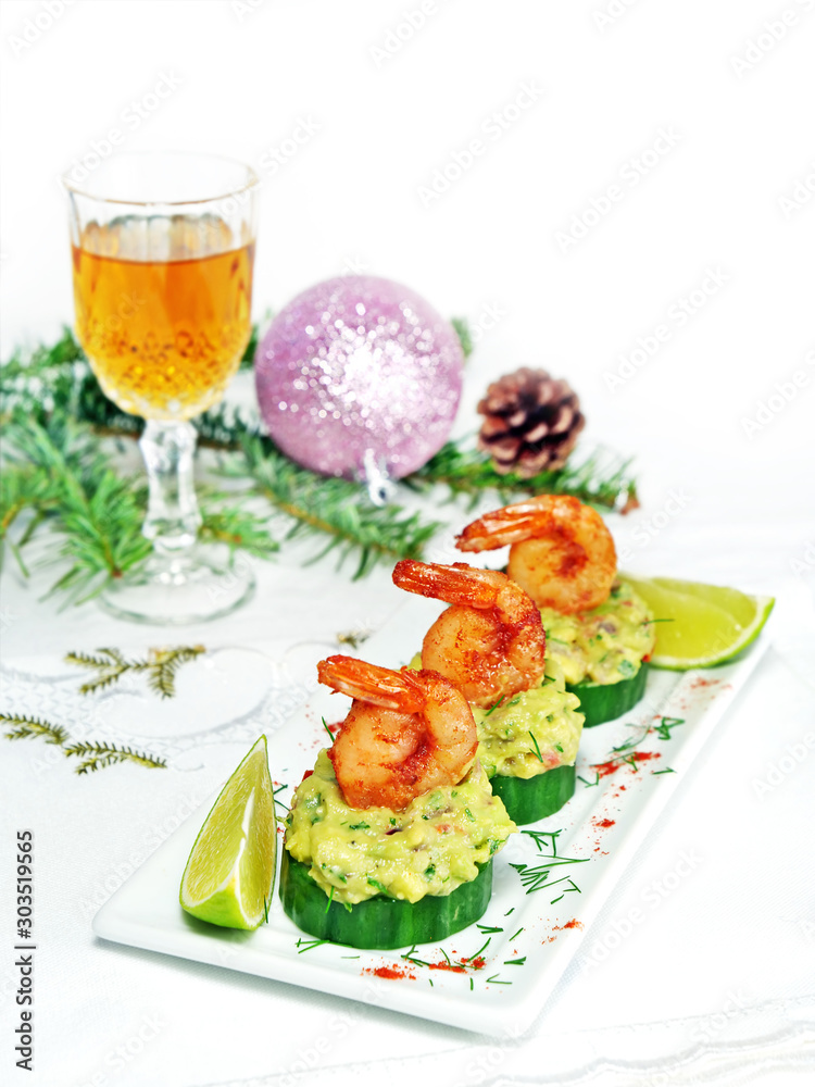 Canape with cucumber, avocado salad and shrimp on white platter on the Christmas table with a glass of bourbon Canape with cucumber, avocado salad and shrimp on white platter on the Christmas table with a glass of bourbon