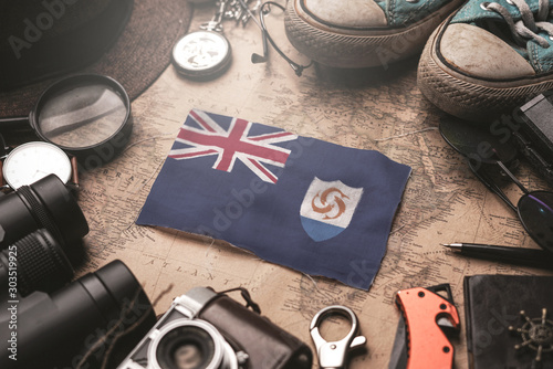 Anguilla Flag Between Traveler's Accessories on Old Vintage Map. Tourist Destination Concept.