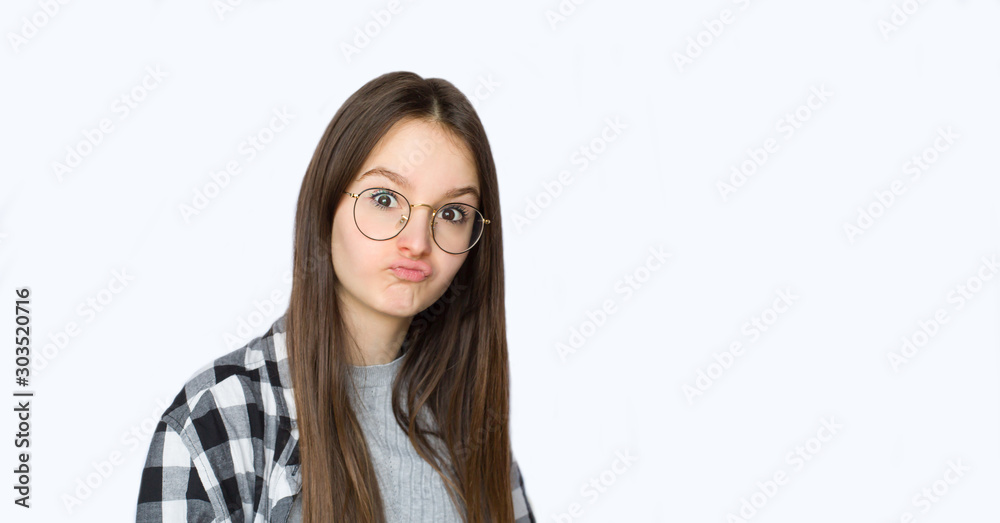 Cute young girl making funny face over white background. Copy space. Cute young girl making funny face over white background. Copy space.