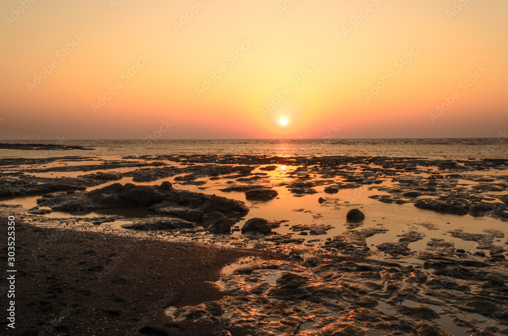 Obraz premium Sunset on Rocky -Devaka Beach Daman India. During Low tide