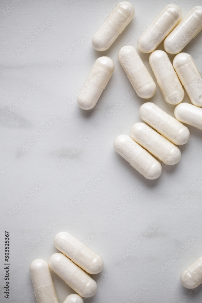 Heap Of Drugs with Glucosamine Sulphate capsules on marble background with copy space Heap Of Drugs with Glucosamine Sulphate capsules on marble background with copy space