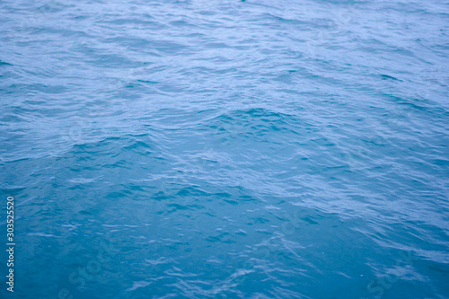 Blue sea surface with waves background.