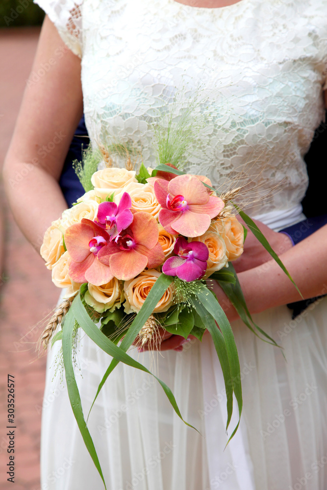 Beautiful wedding bouquet in hands of the bride Beautiful wedding bouquet in hands of the bride