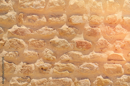 Ancient masonry brickwork with limestone, background. At an archaeological site in Rome. Texture of sandstone bricks, vintage.