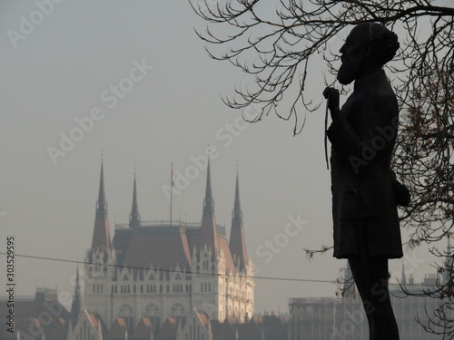 Silhouette of sculpture depicting a person with the background of the Hungarian parliament. photo