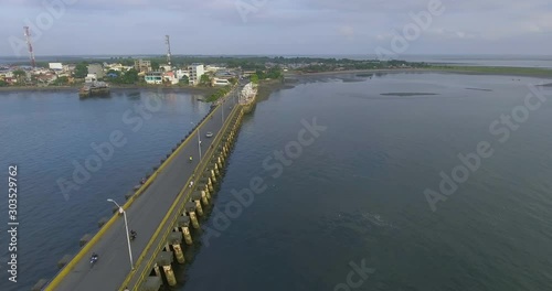 Panoramic shot of a motorboat that crosses under a bridge photo