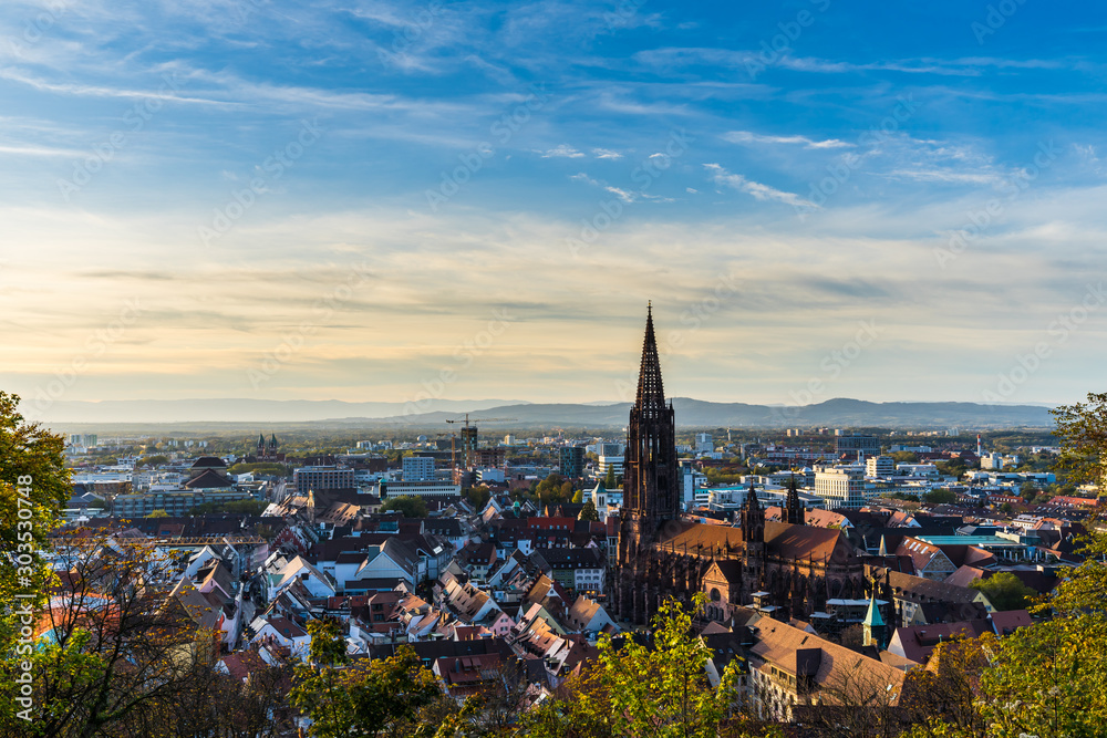 Obraz premium Germany, Freiburg im breisgau skyline with famous cathedral muenster in old town in warm sunset sun light in autumn season, aerial view above cityscape