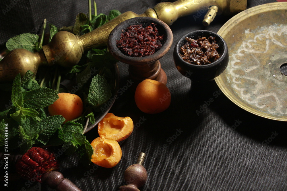 Fototapeta bowl with tobacco for hookah. fruits on a dark background. smoking shisha