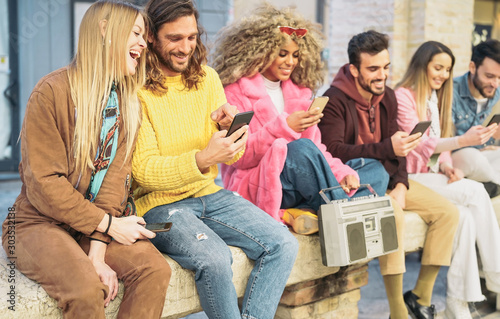 Group happy friends using mobile smartphones in the city - Millennial young people having fun with new trendy apps for social media notworks - Tech generation z and youth lifestyle culture concept