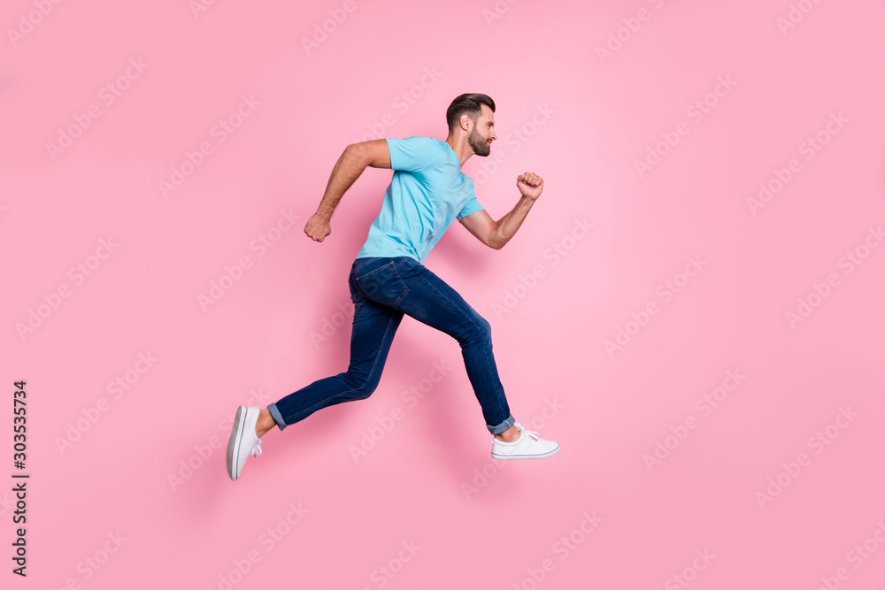 Full length body size side profile photo of man running jumping in footwear aspiring to his goals isolated pastel color background Full length body size side profile photo of man running jumping in footwear aspiring to his goals isolated pastel color background