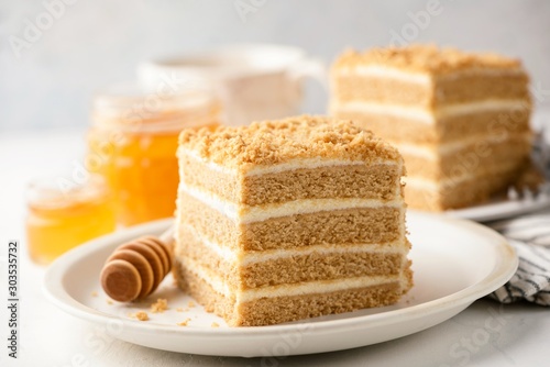 Honey cake with layers and pastry cream on plate, closeup view. Slice of delicious Medovik cake