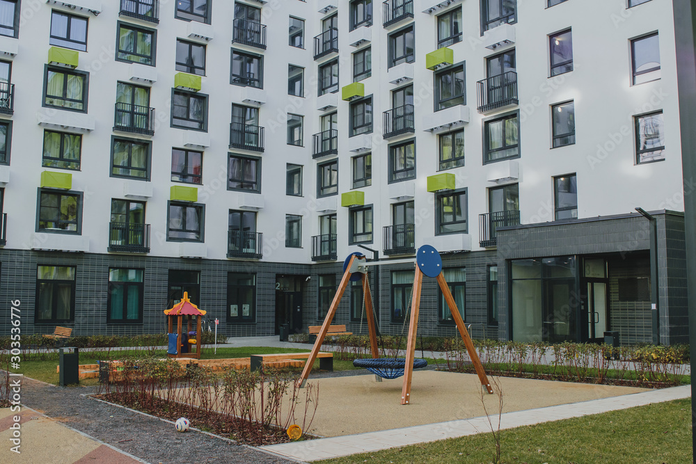 new residential quarter of new buildings: a modern playground in the courtyard of an apartment building with a bright facade 1 new residential quarter of new buildings: a modern playground in the courtyard of an apartment building with a bright facade 1
