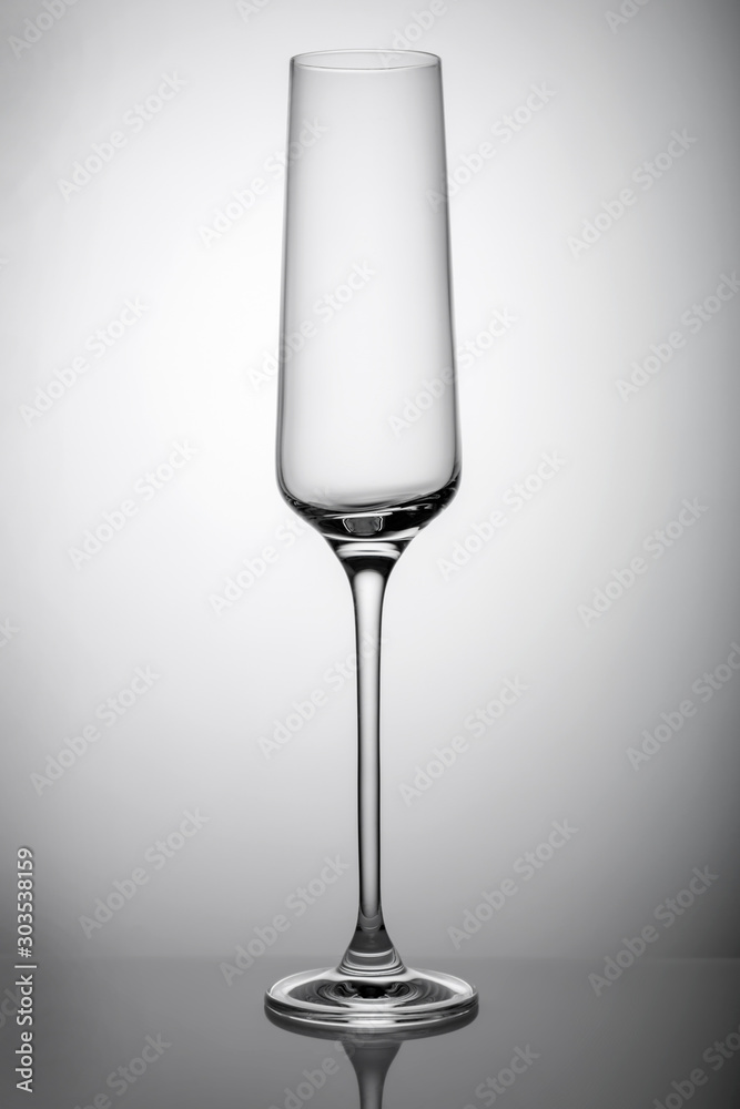an empty glass champagne glass stands on a mirrored surface an empty glass champagne glass stands on a mirrored surface