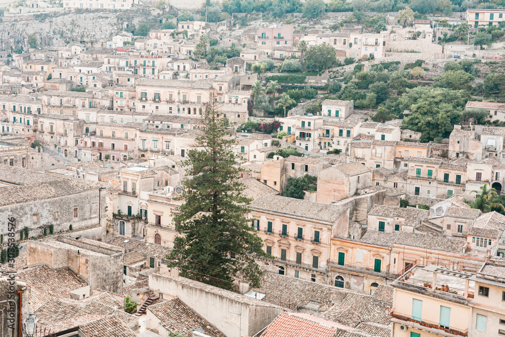 green trees near ancient buildings in modica, Italy