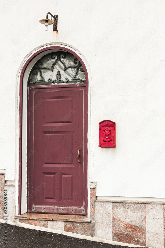 building with red door near vintage post box