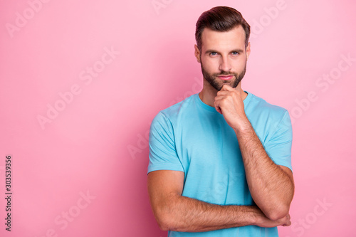 Photo of serious confident man with bristle touching his chin bearded looking at you pensively isolated pink pastel color background