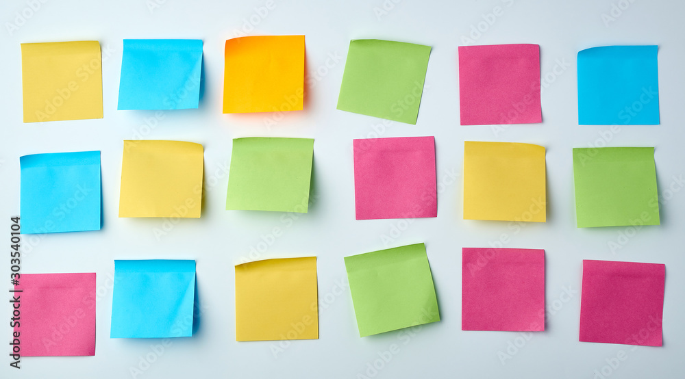 three rows of blank square paper multicolored stickers on a white wall three rows of blank square paper multicolored stickers on a white wall