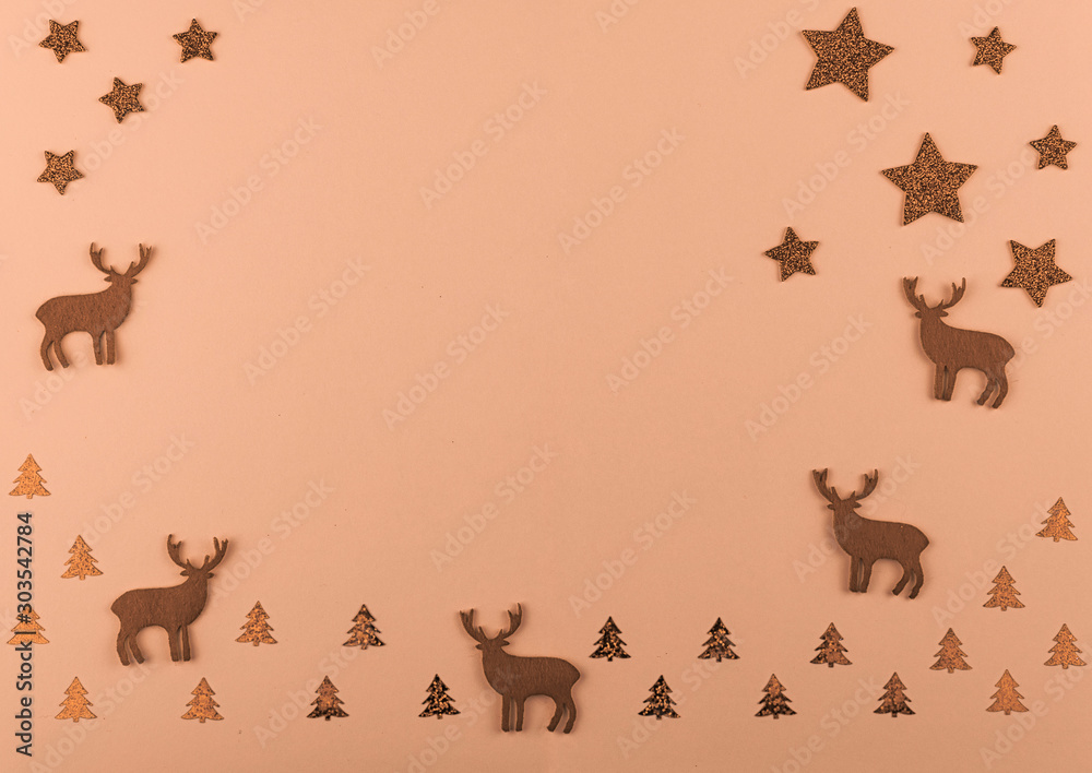 New Year and Christmas composition. Christmas deer and fir-trees, golden decorations on bright peach background.  Flat lay with copy space. Top view