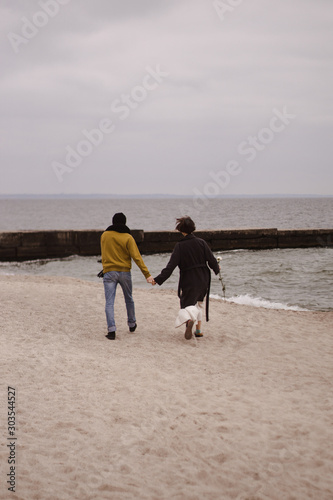 Romantic couple having fun on the beach. Happy couple running on beach