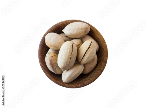 Studio shot of pecans on white background. Pecans in nutshell on wooden bowl isolated on white. Pecans with copy space for text. Nuts close-up.