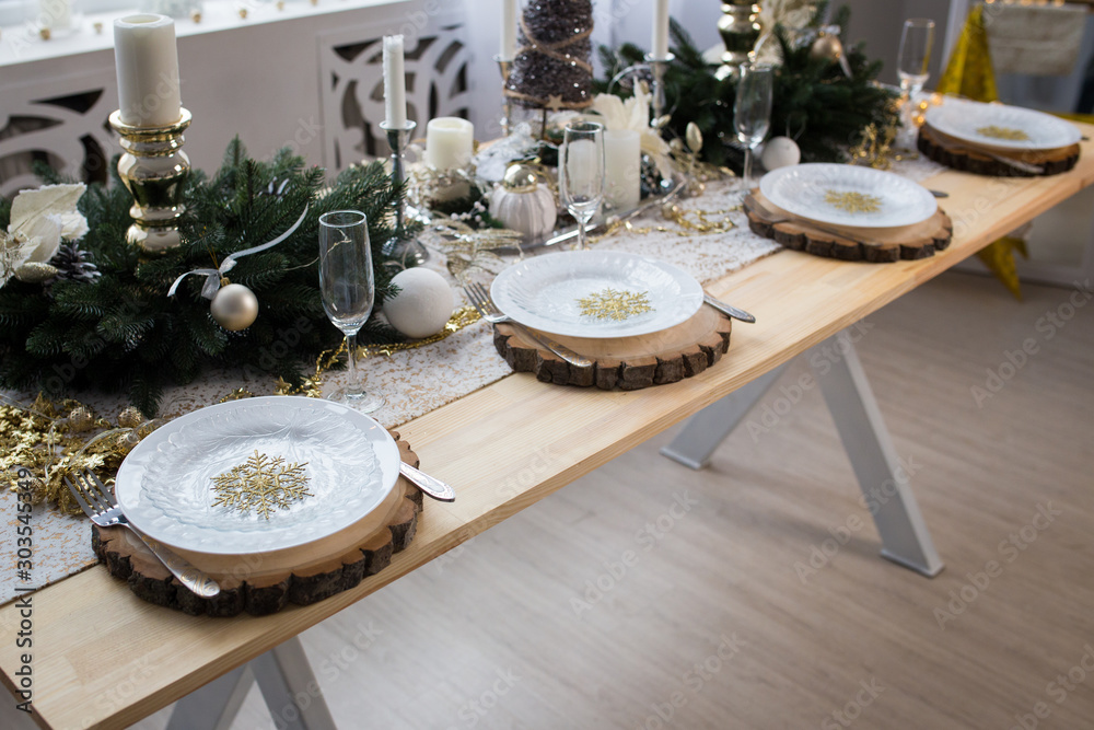 New year table decor. Christmas table with candles, plates and decorations. - obrazy, fototapety, plakaty 