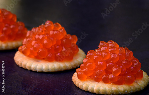 Tartlets with red caviar on dark background