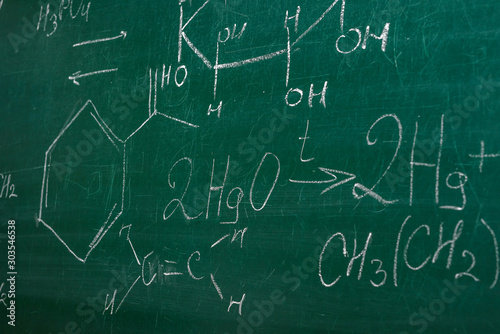 Class blackboard with chemical formulas close up. Education concept